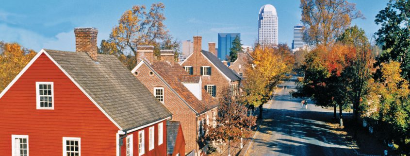 A street view of several homes with city buildings in the background.